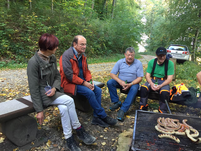 Mitglieder sitzen bei der Jägerhütte am Grill
